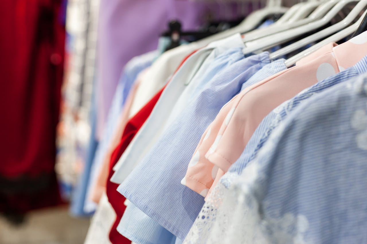 A collection of colorful womens blouses neatly hung on a clothes rack inside a boutique.